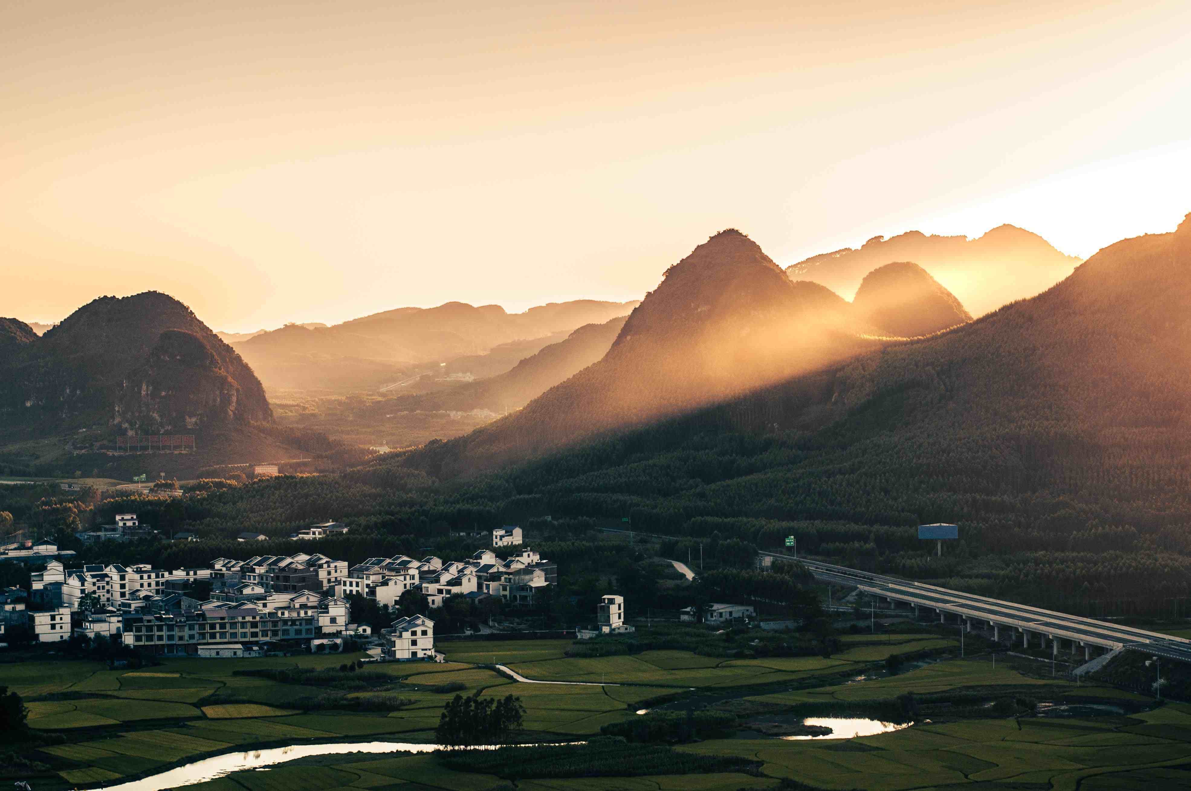 Mountain village with terraced fields and farms nestled in green hills